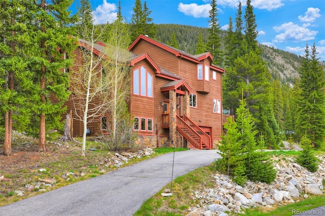 322 Davis Ct, Breckenridge, CO 80424 - chalet / cabin with stone siding, a wooded view, driveway, a garage, and stairs