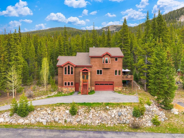 322 Davis Ct, Breckenridge, CO 80424 - chalet / cabin with a forest view, driveway, a garage, stairway, and a wooden deck