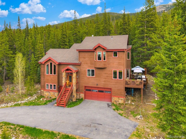 322 Davis Ct, Breckenridge, CO 80424 - rustic home featuring a wooded view, a garage, asphalt driveway, a shingled roof, and stairs