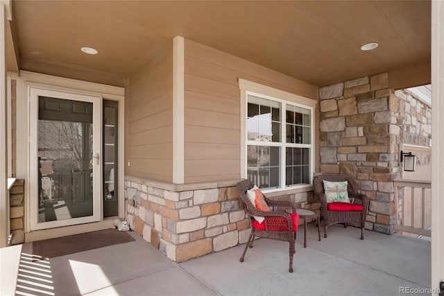 property entrance with stone siding and a porch