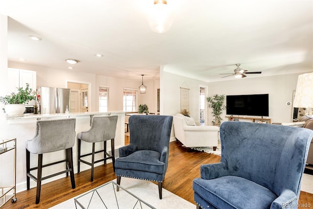 living room with ceiling fan and dark hardwood / wood-style floors