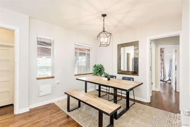 dining area with dark hardwood / wood-style floors and a notable chandelier