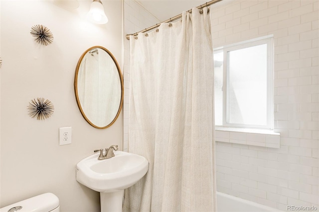 full bathroom with sink, shower / tub combo with curtain, and toilet