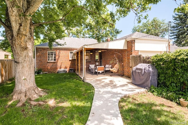 back of property with a yard and a patio