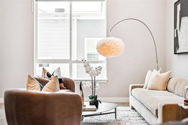 living area with light wood-type flooring and baseboards