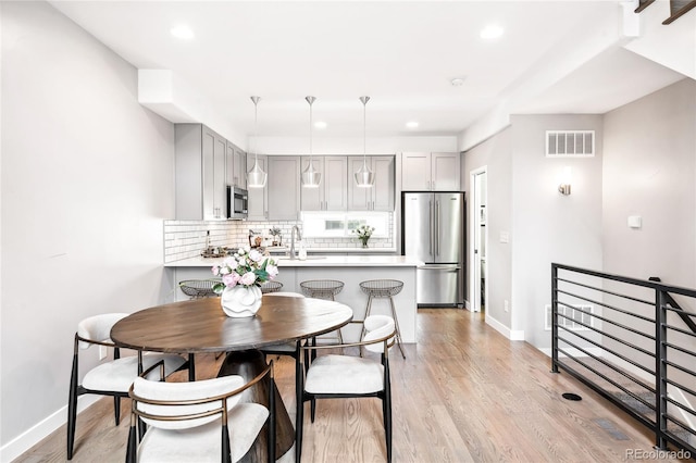 dining space with recessed lighting, visible vents, light wood-style flooring, and baseboards