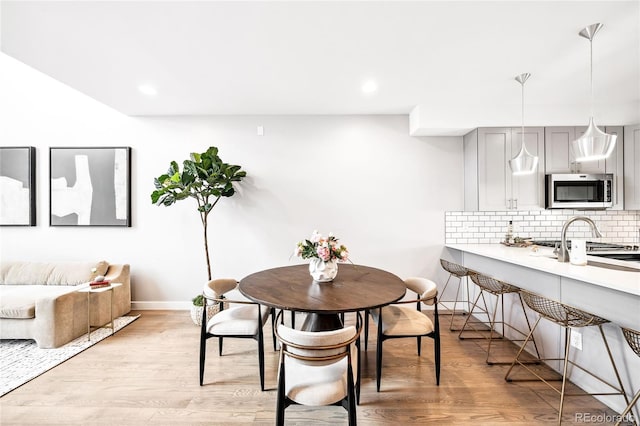 dining space featuring baseboards, recessed lighting, and light wood-style floors