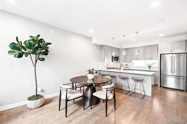 dining room featuring recessed lighting, baseboards, and light wood finished floors