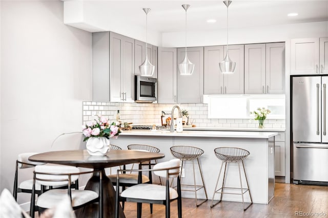 kitchen with stainless steel appliances, a peninsula, and light countertops