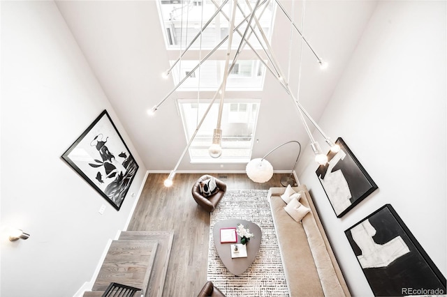 unfurnished living room featuring a high ceiling, wood finished floors, and baseboards