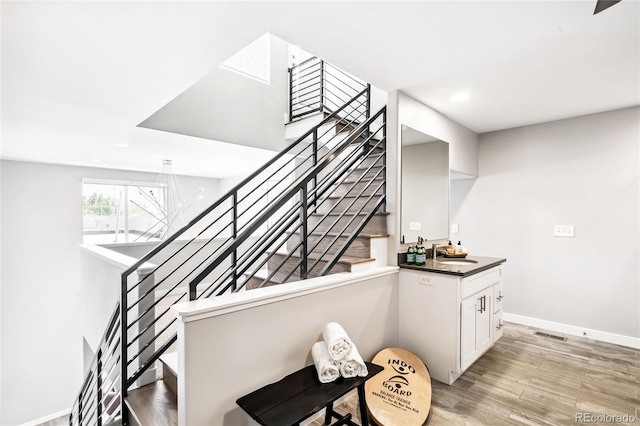 stairs with recessed lighting, wood finished floors, visible vents, and baseboards