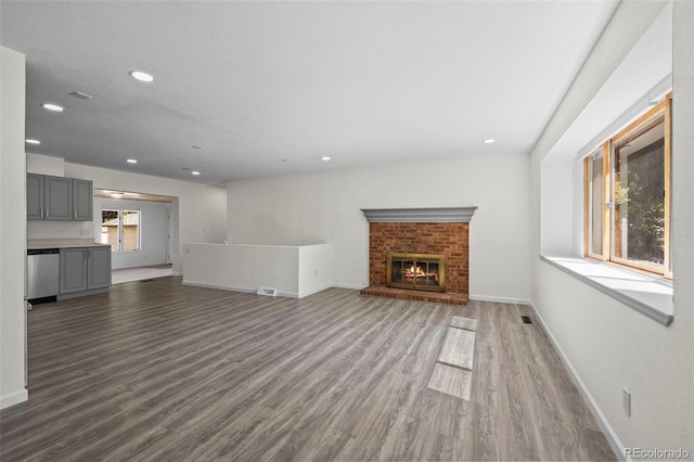 1035 Iris St, Broomfield, CO 80020 - unfurnished living room with wood finished floors, recessed lighting, and a brick fireplace