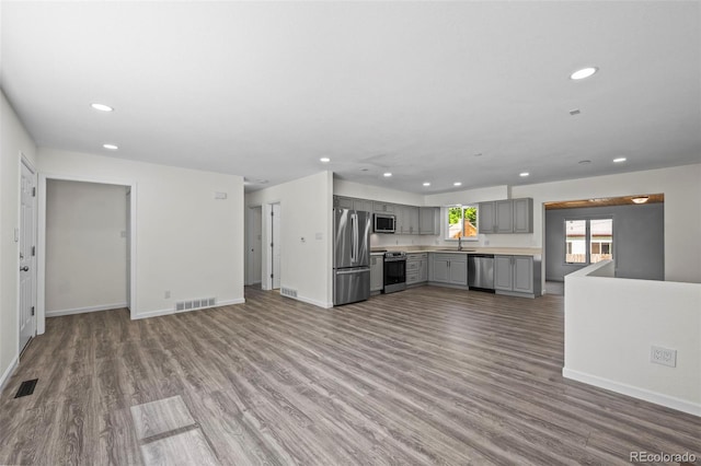 1035 Iris St, Broomfield, CO 80020 - kitchen with gray cabinetry, appliances with stainless steel finishes, recessed lighting, wood finished floors, and light countertops