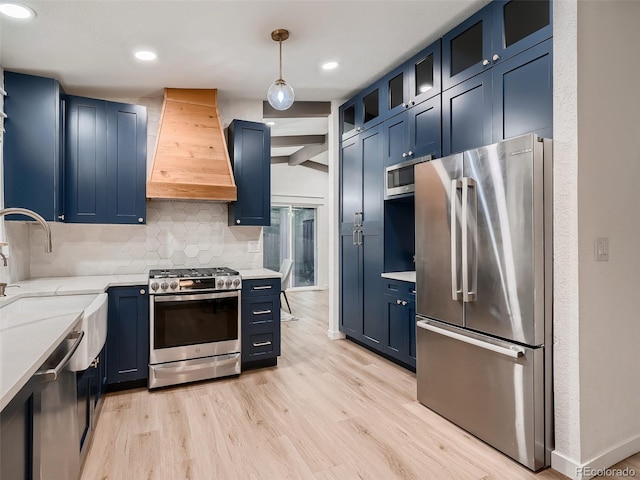 8916 Sunridge Hollow Rd, Parker, CO 80134 - kitchen with blue cabinets, appliances with stainless steel finishes, custom exhaust hood, and tasteful backsplash