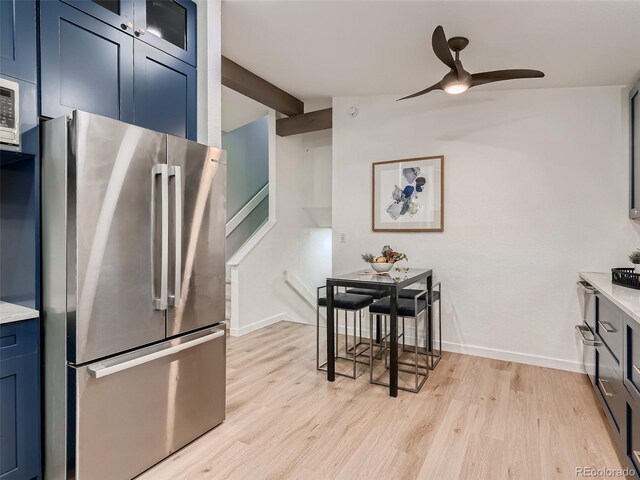 8916 Sunridge Hollow Rd, Parker, CO 80134 - kitchen with light wood-style floors, freestanding refrigerator, ceiling fan, and blue cabinetry