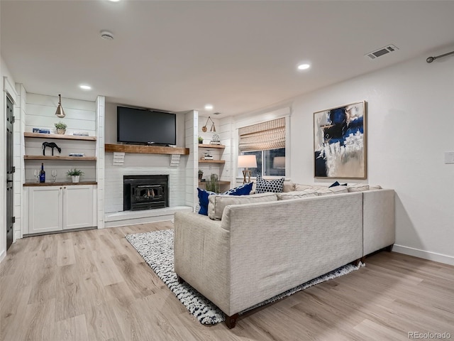 8916 Sunridge Hollow Rd, Parker, CO 80134 - living room featuring visible vents, a brick fireplace, light wood-type flooring, baseboards, and recessed lighting