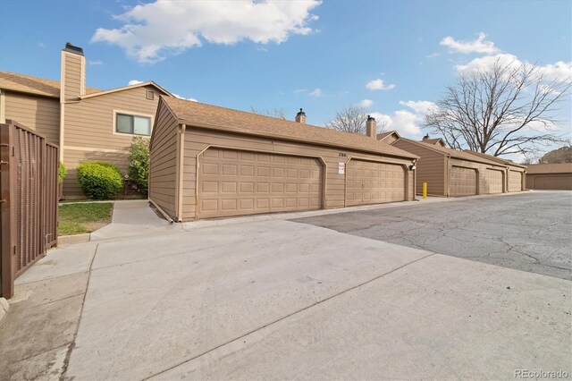 1770 S Quintero Way, Aurora, CO 80017 - view of side of home featuring a chimney, fence, and community garages