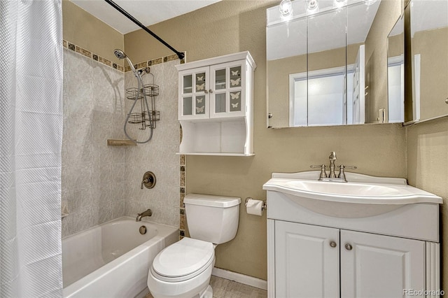 bathroom featuring toilet, baseboards, shower / bath combo with shower curtain, and vanity