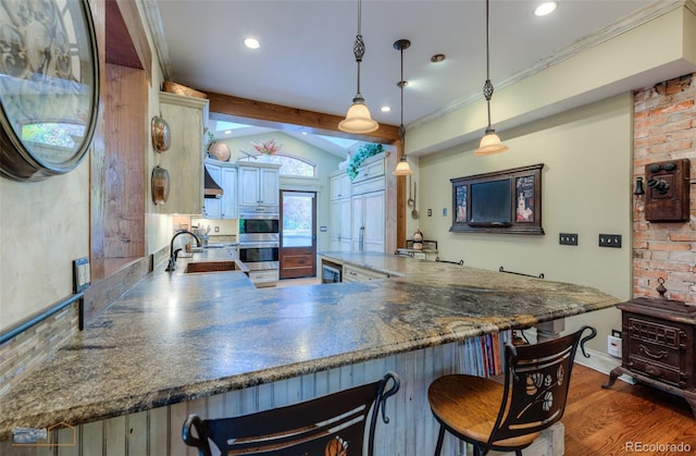 3737 26th St, Boulder, CO 80304 - kitchen featuring stainless steel double oven, a kitchen breakfast bar, dark wood-style flooring, recessed lighting, and pendant lighting