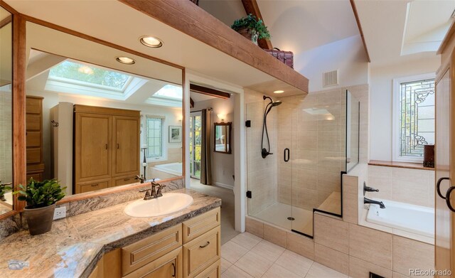 3737 26th St, Boulder, CO 80304 - full bathroom with a skylight, a shower stall, tile patterned flooring, vanity, and a bath