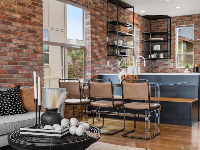 8336 E 35th Ave, Denver, CO 80238 - bar area featuring healthy amount of natural light, wood finished floors, brick wall, and a sink