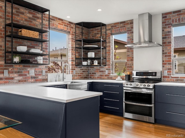 8336 E 35th Ave, Denver, CO 80238 - kitchen featuring range with two ovens, wall chimney range hood, open shelves, a sink, and brick wall