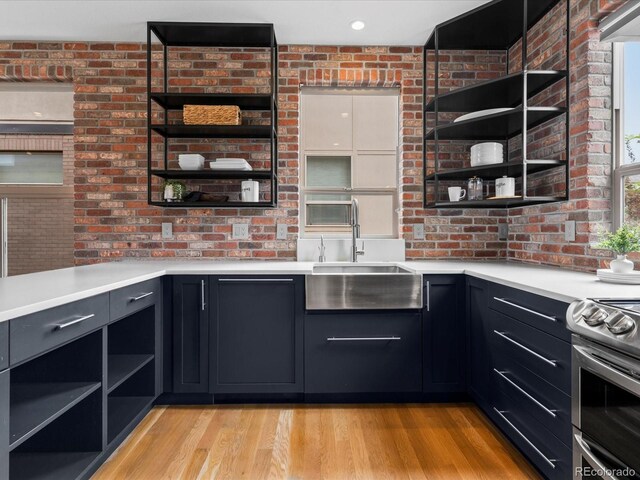 8336 E 35th Ave, Denver, CO 80238 - kitchen with open shelves, a sink, electric stove, light countertops, and brick wall