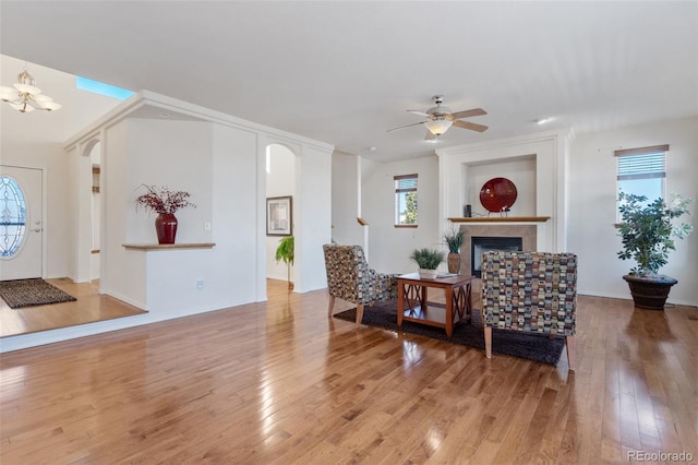 living room featuring ceiling fan with notable chandelier and wood-type flooring