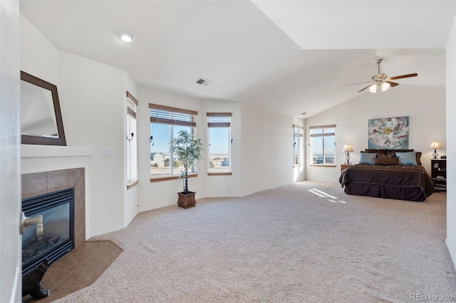 carpeted bedroom featuring ceiling fan, vaulted ceiling, and a fireplace