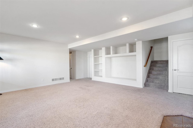 unfurnished living room with built in features and carpet flooring