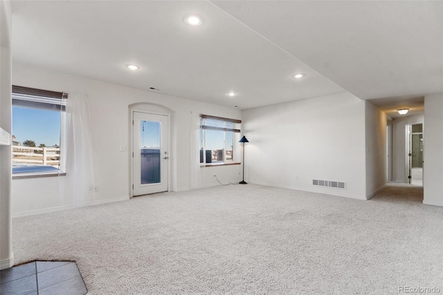 unfurnished living room featuring plenty of natural light and light colored carpet