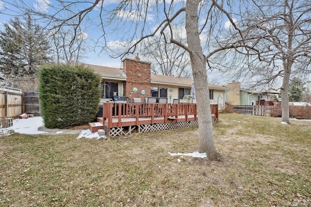 back of house featuring a wooden deck and a yard