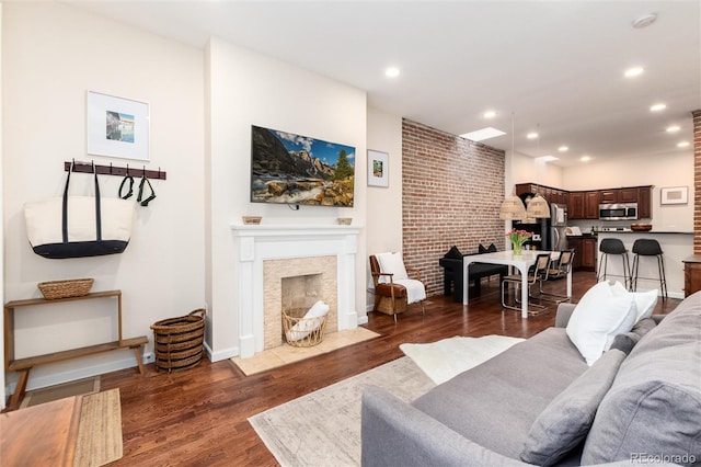 living room featuring dark wood-style flooring, baseboards, a fireplace with flush hearth, and recessed lighting