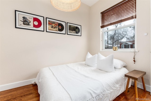 bedroom featuring wood finished floors and baseboards