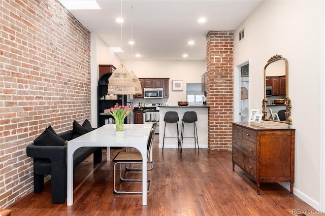 3220 W 24th Ave, Denver, CO 80211 - dining room with dark wood finished floors and brick wall