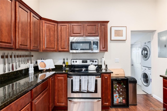 3220 W 24th Ave, Denver, CO 80211 - kitchen with appliances with stainless steel finishes, estacked washer and dryer, wood finished floors, electric panel, and dark stone counters