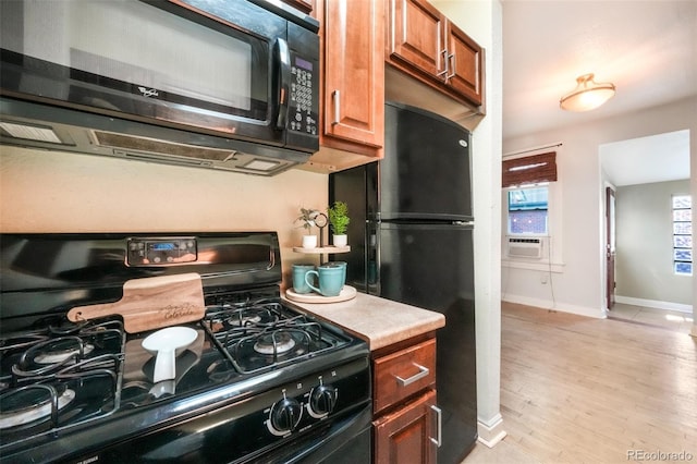 22 E Bayaud Ave, Denver, CO 80209 - kitchen featuring black appliances, light wood-style flooring, brown cabinetry, light countertops, and cooling unit
