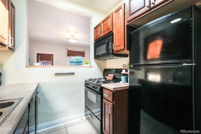 22 E Bayaud Ave, Denver, CO 80209 - kitchen featuring black appliances, light tile patterned flooring, light countertops, brown cabinets, and a textured wall