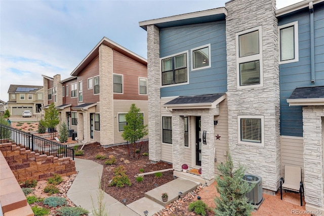 9279 Merino Ct Unit D, Littleton, CO 80125 - view of front of house with stone siding, central AC unit, and a residential view