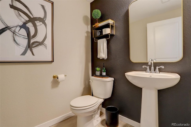 9279 Merino Ct Unit D, Littleton, CO 80125 - half bathroom featuring baseboards, wood finished floors, and toilet