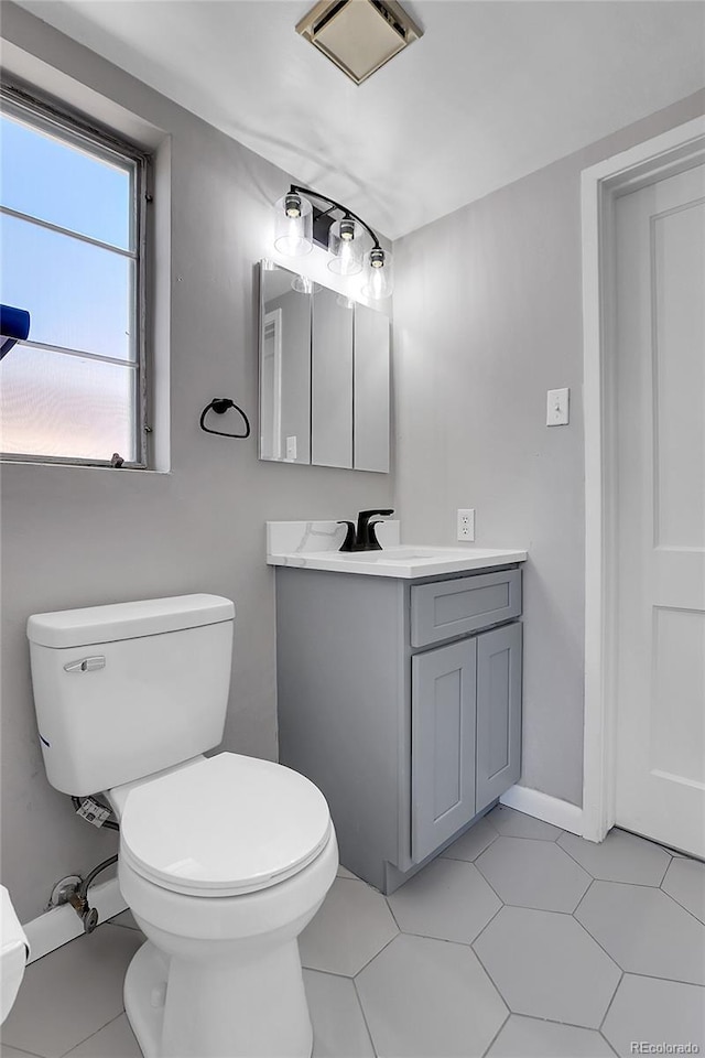 891 Ursula St, Aurora, CO 80011 - half bath with vanity, toilet, tile patterned flooring, and baseboards