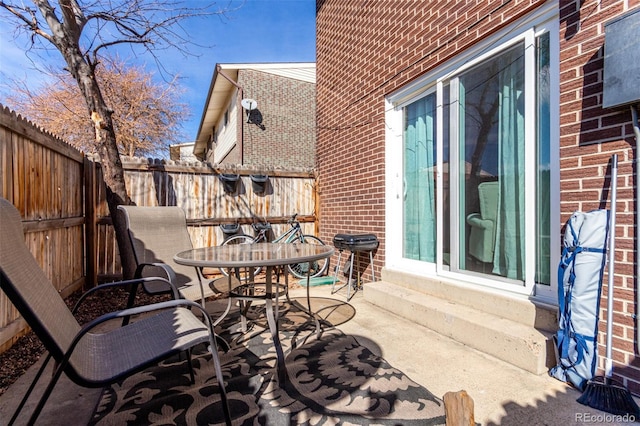 view of patio featuring entry steps, outdoor dining area, and fence