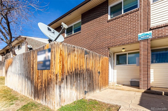 view of home's exterior with brick siding and fence