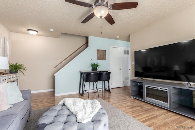 living room with stairway, a textured ceiling, and wood finished floors