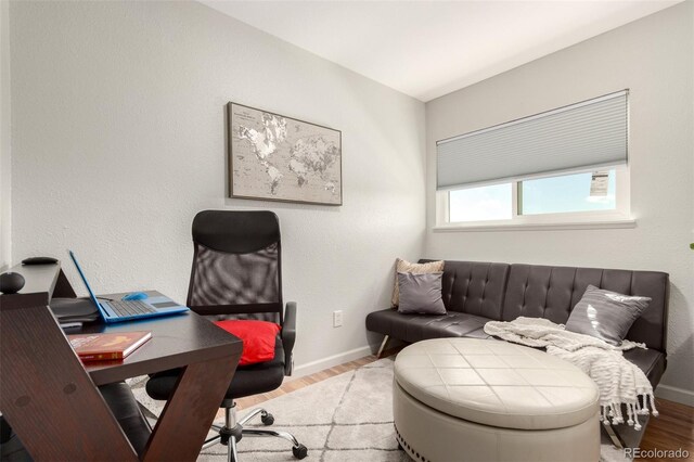 office space with light wood-type flooring and baseboards