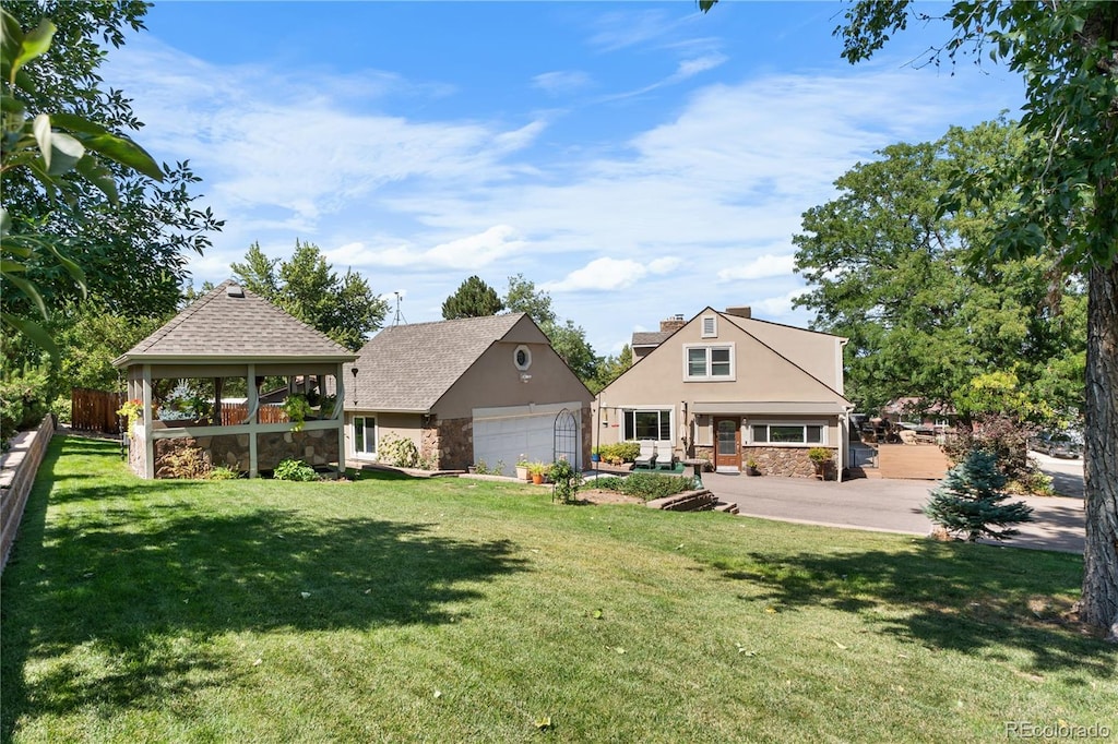 back of house featuring an outbuilding, a gazebo, and a lawn