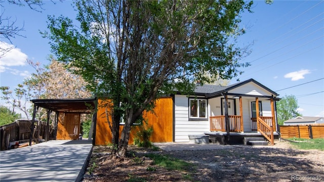 2441 W 55th Ave, Denver, CO 80221 - view of front facade featuring fence, driveway, and a carport