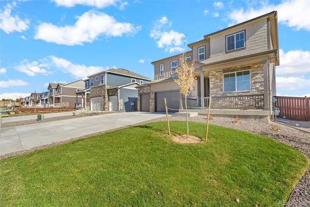 traditional home with a front lawn, a residential view, a garage, stone siding, and driveway