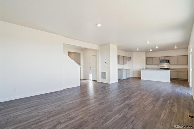 unfurnished living room with recessed lighting, visible vents, baseboards, and dark wood-type flooring