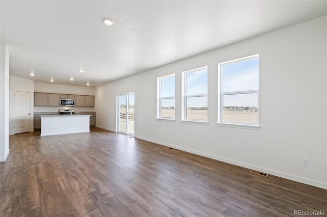 unfurnished living room featuring dark wood-style floors, visible vents, recessed lighting, and baseboards